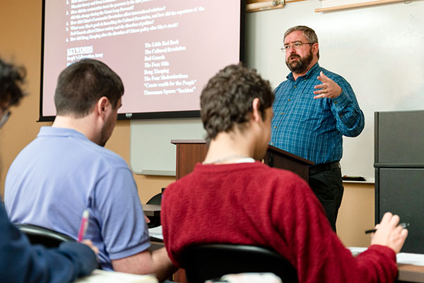 professor lecturing in front of a class of students