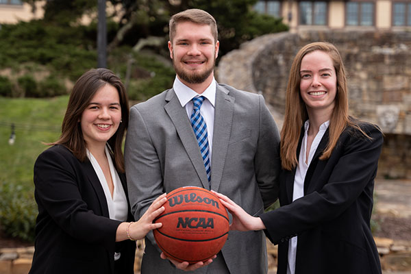 students posing with basketball